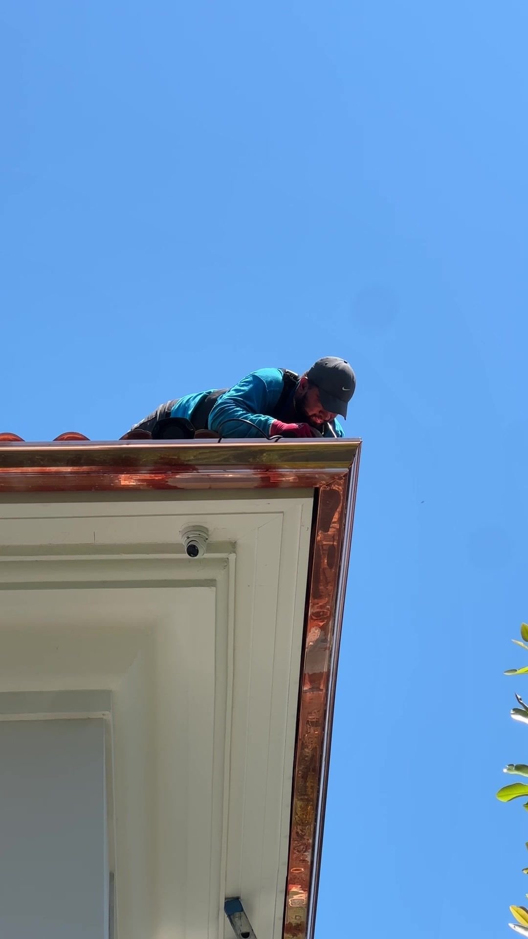 Instalador de Emme Gutters colocando una canaleta de cobre en una casa de Miami
